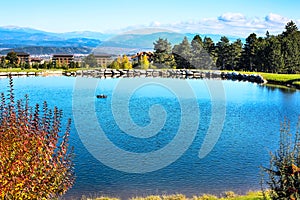 Beautiful blue Lake, pine trees, wooden houses and mountains view background