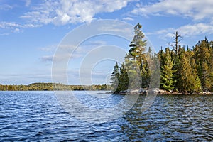 Beautiful blue lake and shoreline with pines in the Boundary Waters Canoe Area Wilderness of northern Minnesota on a bright autumn photo