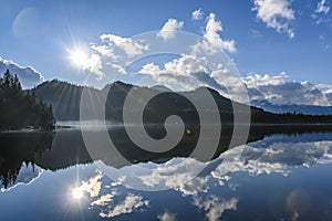 Beautiful blue lake with surrounding mountains reflecting back