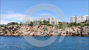 Beautiful blue Mediterranean sea with waves and shore with various buildings and hotels
