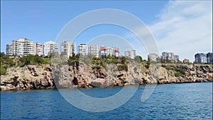 Beautiful blue Mediterranean sea with waves and shore with various buildings and hotels