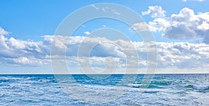 Beautiful, blue ocean view of the sea with white clouds on a beach day in summer. Outdoors tidal landscape of calm water