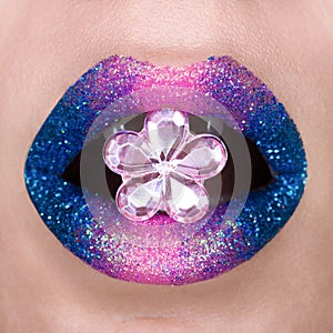 Beautiful blue and pink lips with sparkles. Pink blue lipstick. Gemstone in shape of flower, open mouth. Lip art