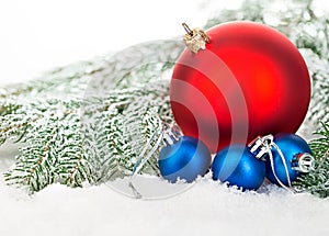 Beautiful blue and red Christmas balls on frosty fir tree. Christmas ornament.