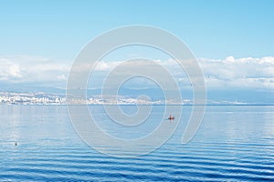 Beautiful blue sea with fishing boat. View of Rijeka city, Croatia