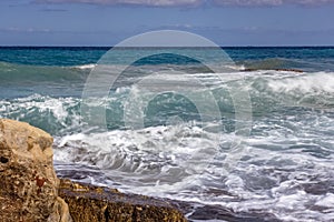 Beautiful blue sea waters and white waves sloping towards the coast