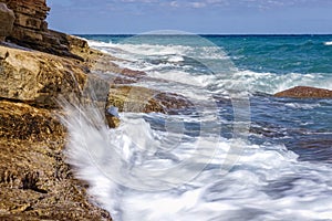 Beautiful blue sea waters and white waves sloping towards the coast