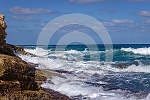 Beautiful blue sea waters and white waves sloping towards the coast