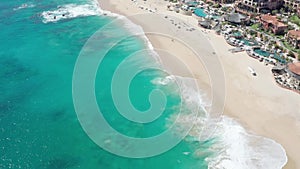 Beautiful blue sea, waves and beach overlooking resort in Cabo