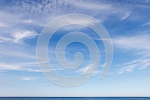 Beautiful blue sky over the sea with translucent, white, Cirrus clouds