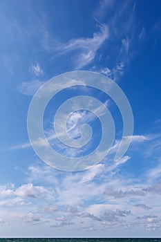 Beautiful blue sky over the sea with translucent, white, Cirrus clouds