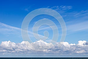 Beautiful blue sky over the sea with translucent, white, Cirrus and Cumulus clouds. Skyline