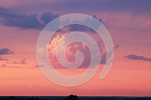 Beautiful blue sky with pink clouds illuminated by the setting sun. Sunset, evening, cumulus