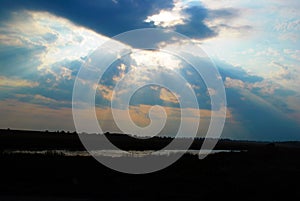 Beautiful blue sky with sunbeams and clouds. Sun rays