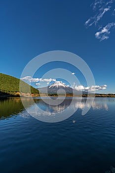 Beautiful blue sky at Tanuki Lake Tanukiko. Fuji mountain reflections, first snow in autumn season. Japan