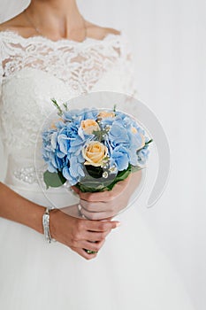 Beautiful blue and yellow fresh flowers wedding bouquet. Bride with wedding bouquet, closeup