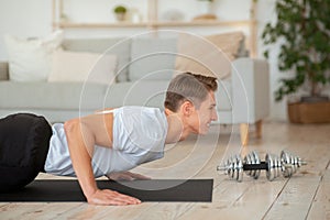 Beautiful body and sport at home. Guy doing push-ups on living room floor