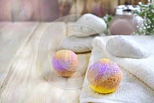 Beautiful bodycare cosmetic composition with spa salt balls, cosmetic scrub jar, stones, towel on wooden background.