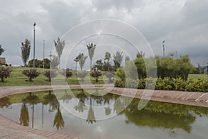 A beautiful bogota metropolitan park scene with water tree reflection and grey cloudy sky