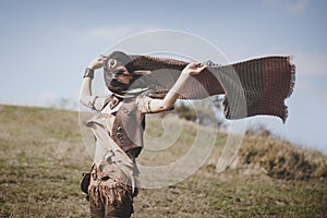 Beautiful boho girl holding scarf on the wind in nature