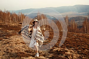 Beautiful boho woman hipster having fun, wearing hat and poncho