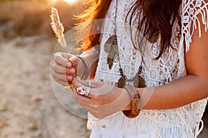 Beautiful boho woman in a sunny field at sunsrt.