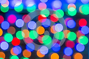 Beautiful bokeh in the form of medium-sized multicolored circles against a dark background