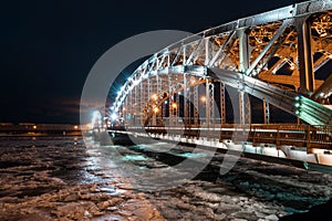 Beautiful Bolsheokhtinsky bridge at night.Iron structure of the arched bridge. Metal beams, spans, bolts and rivets.Side view of B