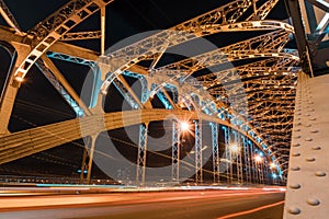 Beautiful Bolsheokhtinsky bridge at night.Iron structure of the arched bridge. Metal beams, spans, bolts and rivets.Side view of B