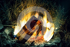 Beautiful bonfire with flying sparks pattern. Large firewood fire burn in pitch darkness