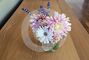 Beautiful bouquet of an assortment of annuals and perennial flowers on a hardwood table photo