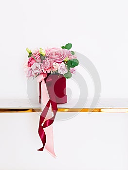 Beautiful bouquet of blooming flowers in red flower box on white background, holiday gift, luxury floral design