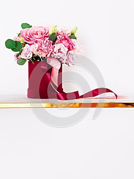 Beautiful bouquet of blooming flowers in red flower box on white background, holiday gift, luxury floral design