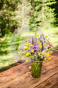 Beautiful bouquet of bright wildflowers on a wooden table
