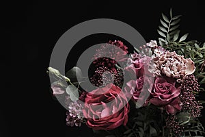 Beautiful bouquet of different flowers on black background. Floral card design with dark vintage effect