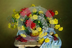 A beautiful bouquet of flowers.Flowers of colorful dahlias , red berries,fruits on the table