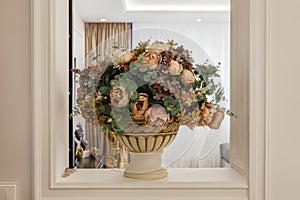 Beautiful bouquet of flowers in a vase in the interior of the house