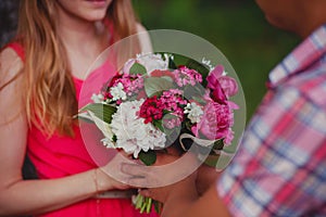 Beautiful bouquet in the hands of a young couple in love