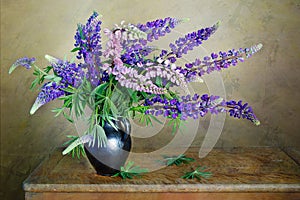A beautiful bouquet of lupines in a vase isolated on a green background