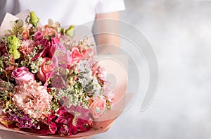 Beautiful bouquet of mixed flowers in female hands. roses, eustomas, alstroemerias. photo
