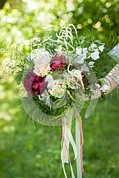 Beautiful bouquet of peonies in woman`s hands