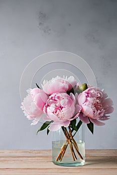 beautiful bouquet of pink peonies in glass vase on table