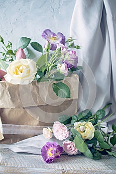 A beautiful bouquet of pink roses in a craft paper bag