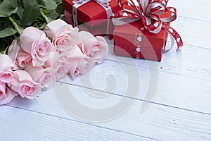 Beautiful bouquet of pink roses and red present boxes