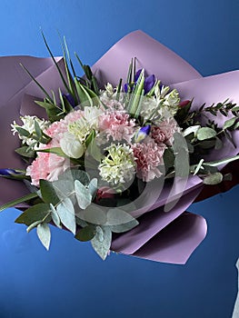 A beautiful bouquet of pink and white tulips, hyacinths, irises and fluffy carnations with the addition of green eucalyptus