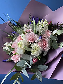 A beautiful bouquet of pink and white tulips, hyacinths, irises and fluffy carnations with the addition of green eucalyptus