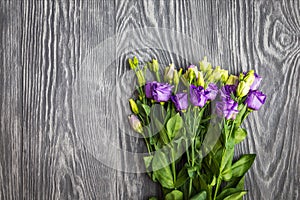 Beautiful bouquet from purple eustoma flowers on dark wooden bac