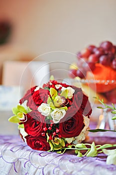 Beautiful bouquet of rose flowers on table. Wedding bouquet of red roses. Elegant wedding bouquet on table at restaurant