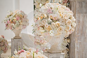 Beautiful bouquet of roses in a vase on a background of a wedding arch. Beautiful set up for the wedding ceremony