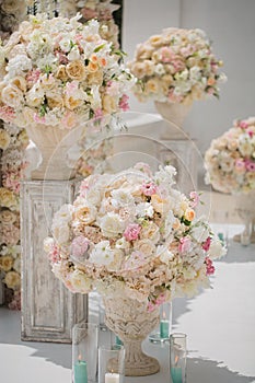 Beautiful bouquet of roses in a vase on a background of a wedding arch. Beautiful set up for the wedding ceremony.